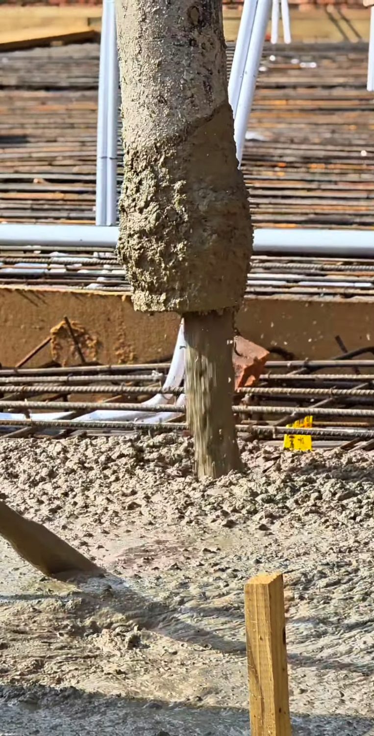 Concrete being pumped onto a slab